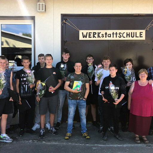 Gruppenbild vor dem Eingangsbereich zur Werkstatt