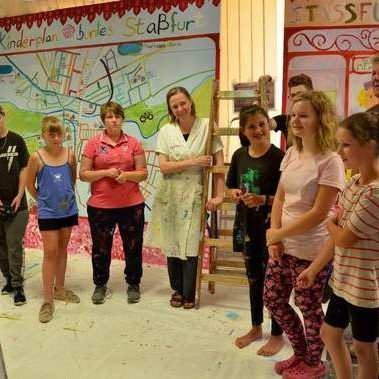 Gruppe von Kindern die sich ein Bild anschaut