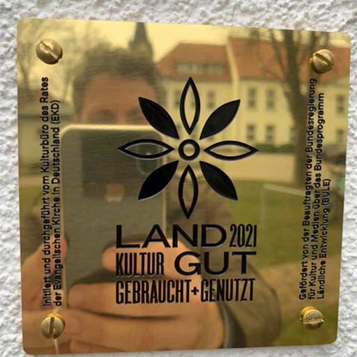 Goldenes Schild mit dem Projektlogo LANDGUT 2021